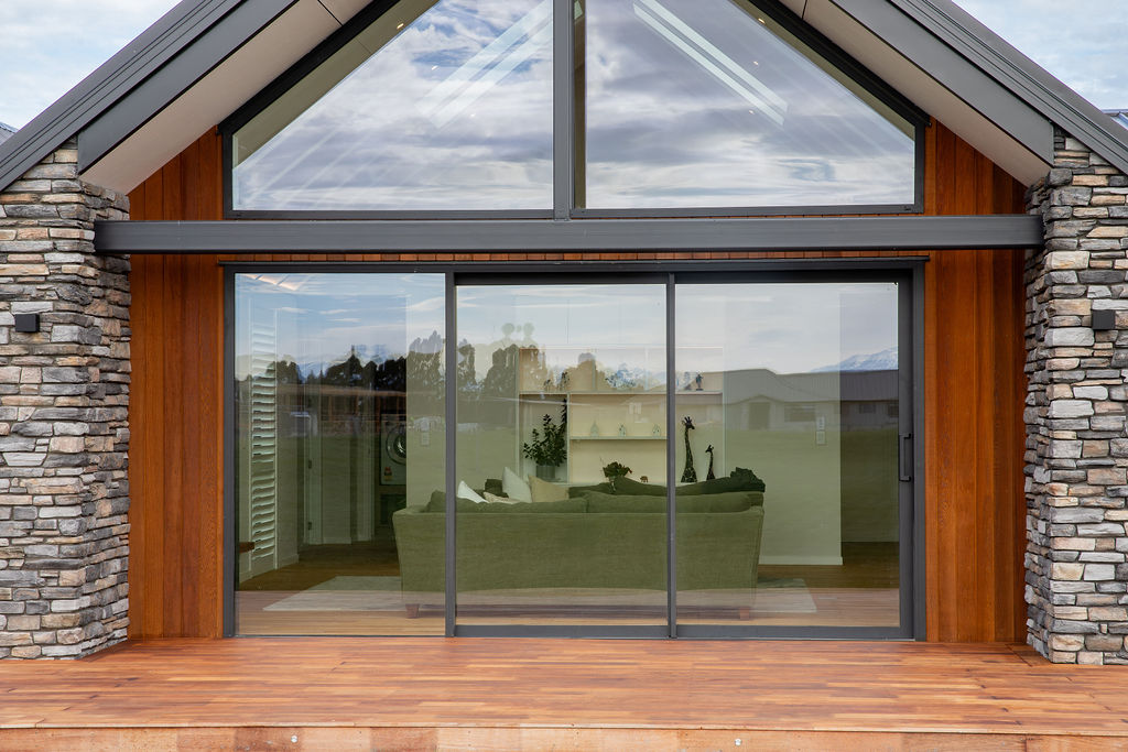 Gable end with full-height glazing, cedar cladding and deck by Mt Hutt Construction
