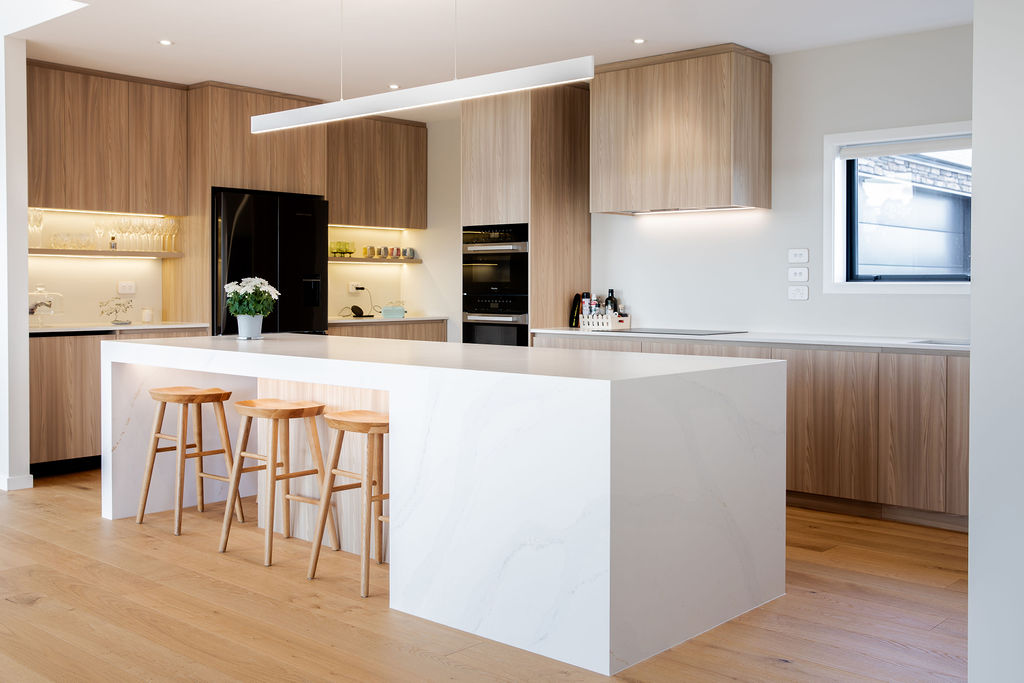 Kitchen island with waterfall stone benchtop and timber cabinetry by Mt Hutt Construction